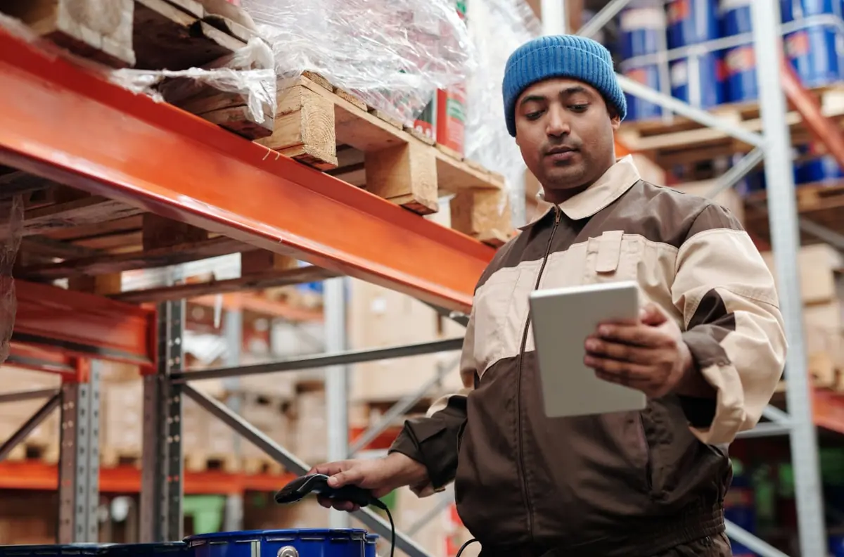 A warehouse worker checking inventory on a tablet